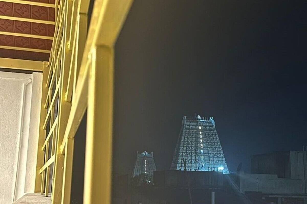 A view of a building with a pyramid-like structure at night, illuminated by lights.