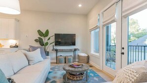 A modern living room with a sofa, coffee table, and a flat-screen TV.