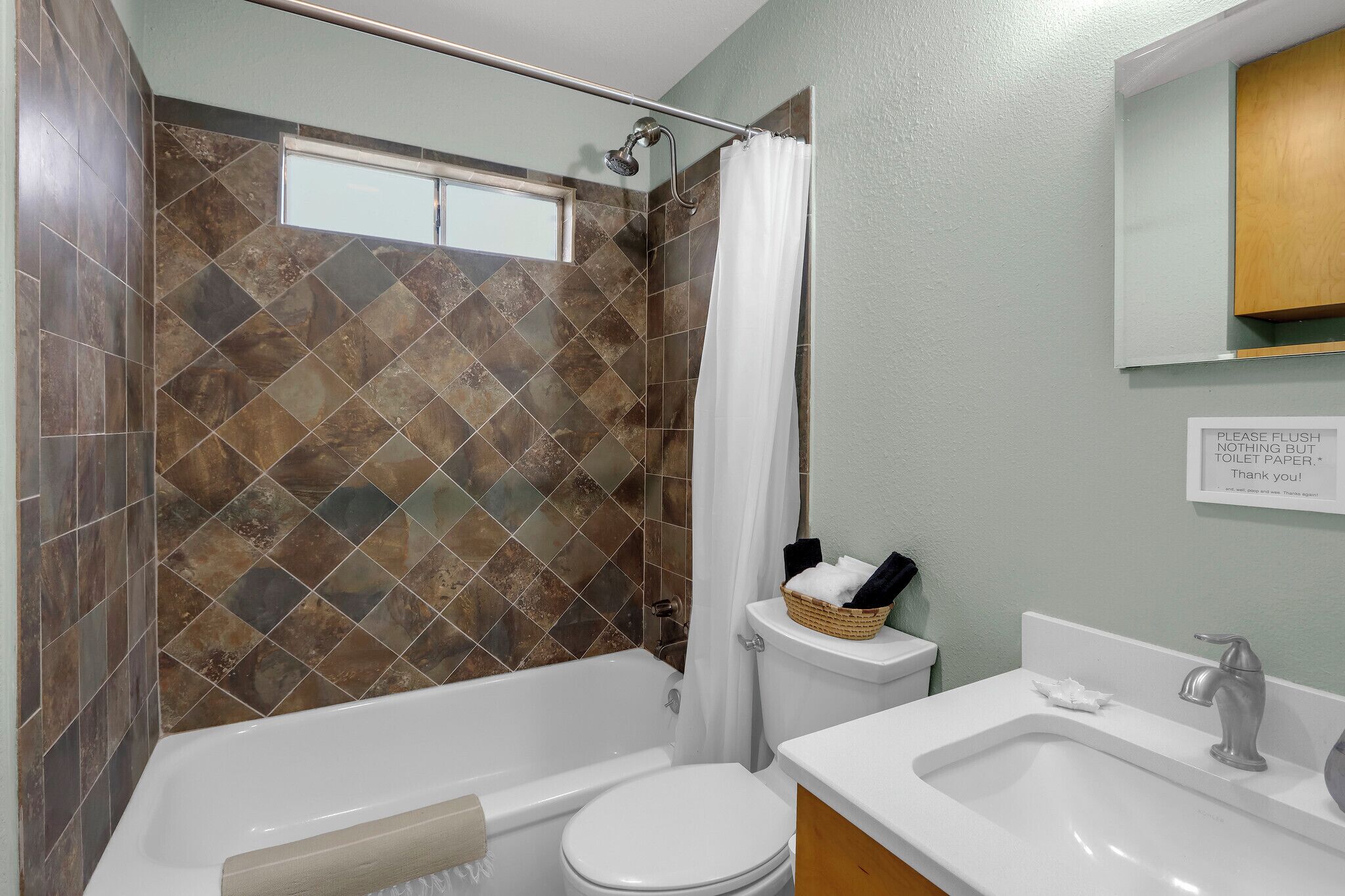 Een badkamer met een douche, toilet en wastafel.