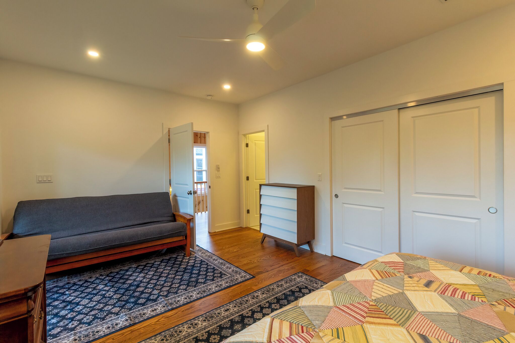 Une chambre à coucher comprenant un lit, un canapé, une commode et une armoire.