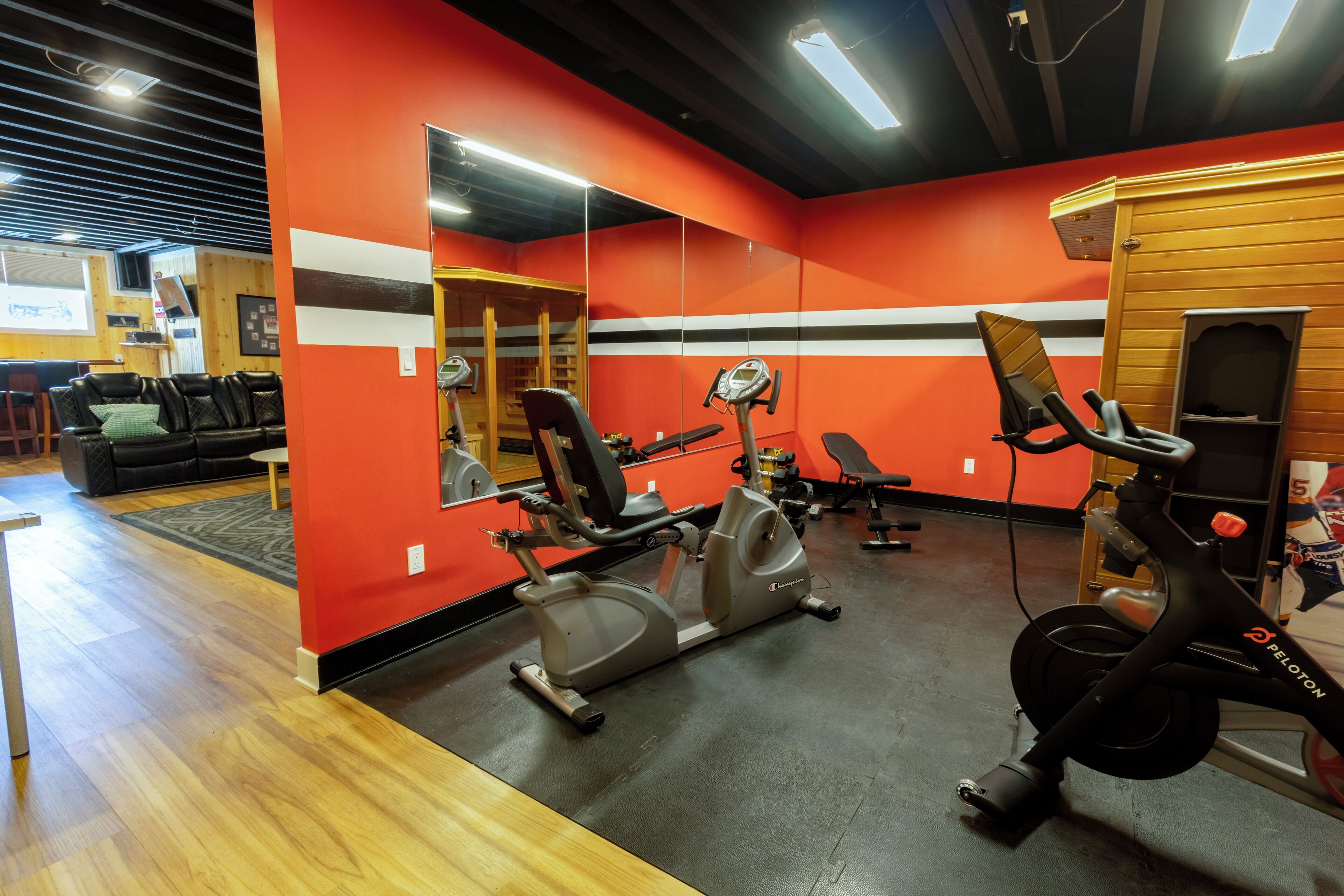 A gym with exercise equipment, a mirror, and a wooden wall.