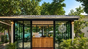 A modern building with a reception desk, glass walls, and a logo. - Abode Hua Hin (Hua Hin)