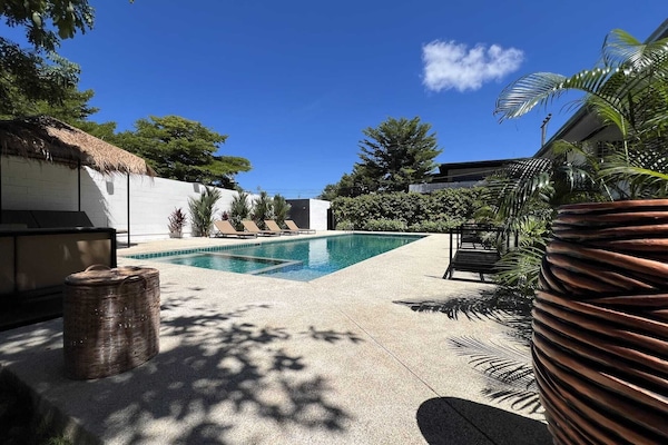 Una piscina al aire libre, camas de piscina gratis, sombrillas