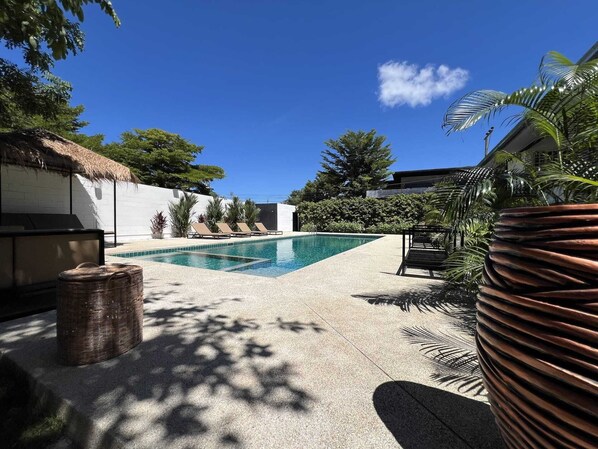 Una piscina al aire libre, camas de piscina gratis, sombrillas