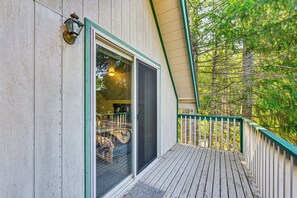 Une terrasse en bois avec une porte vitrée donnant sur une pièce.