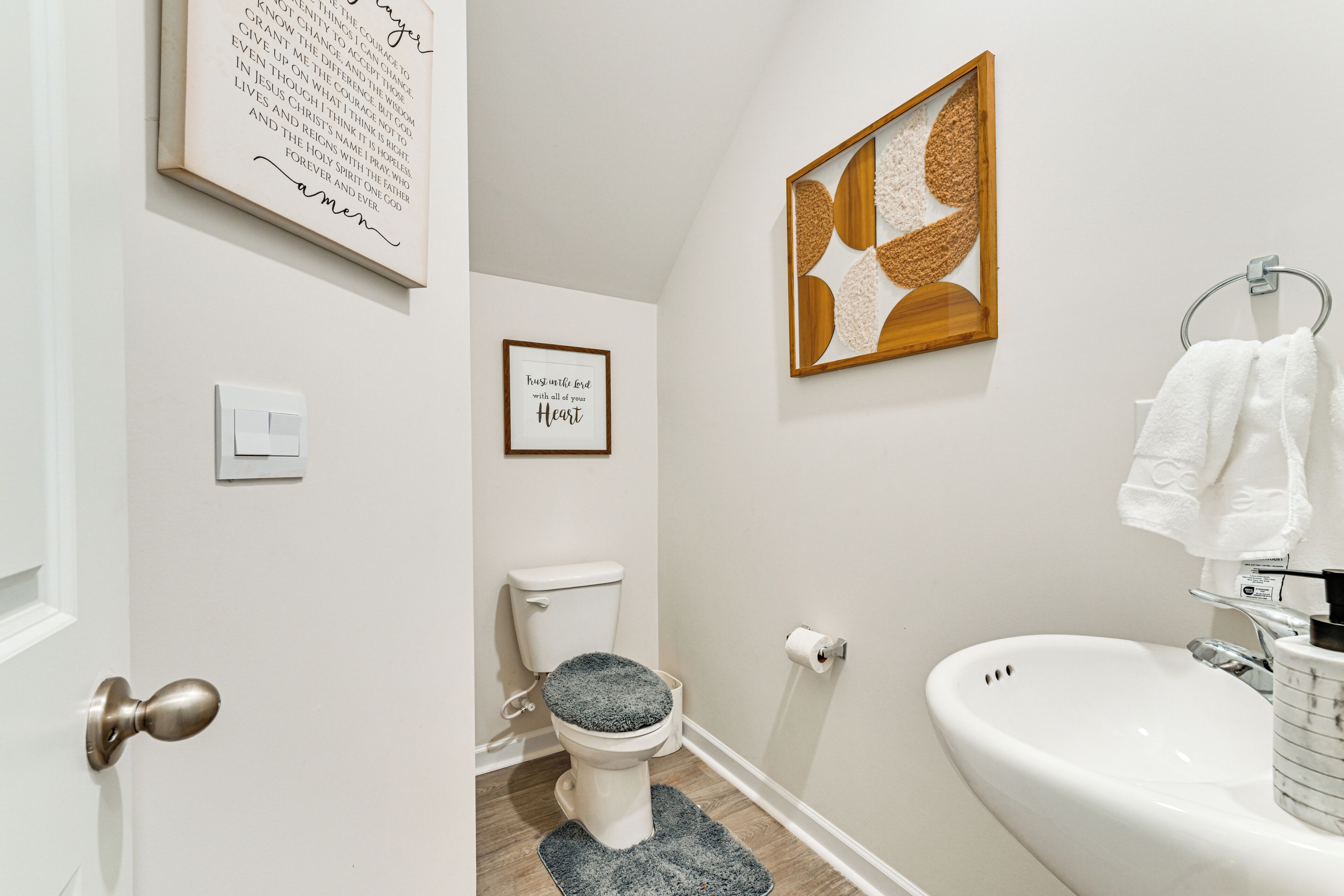 A bathroom with a toilet, sink, and towel rack.