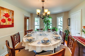 A dining room with a round table set for six, surrounded by wooden chairs. - 15 Mi to Louisville: Family Home w/ Private Yard! (Louisville)