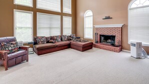 A living room with a sectional sofa, a fireplace, and large windows. - 4 Mi to Dulles Airport: Spacious D.c. Area Home (Herndon)