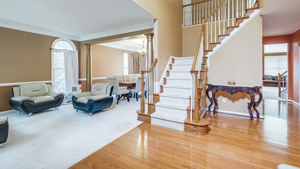 A spacious living room with a wooden staircase, a dining area, and a view of the outdoors. - 4 Mi to Dulles Airport: Spacious D.c. Area Home (Herndon)