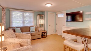 A cozy living room with a sofa, a small round table, and a wooden dining table with white chairs. - Fish & Hike: Lakeside Poconos Retreat, Unit 4 (Bangor)