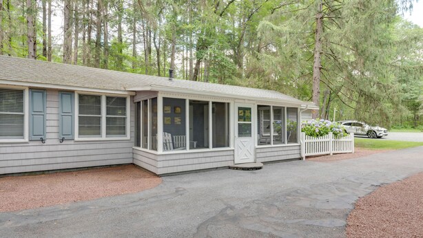 A two-story building with a covered porch and a driveway. - Fish & Hike: Lakeside Poconos Retreat, Unit 4 (Bangor)