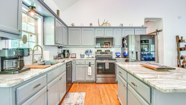 A modern kitchen with grey cabinets, stainless steel appliances, and a wooden floor. - Hiawassee Cabin Near Lake Chatuge + AT Trailheads (Hiawassee)