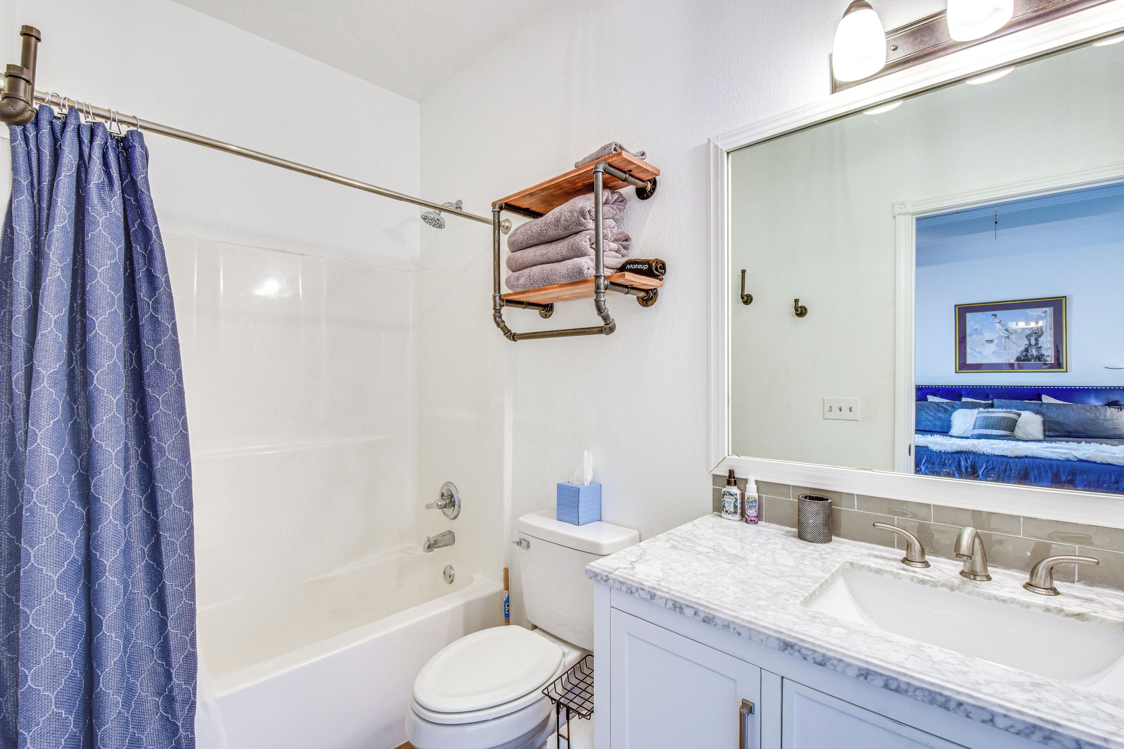 Une salle de bain équipée d’une douche, de toilettes, d’un lavabo et d’un porte-serviettes.