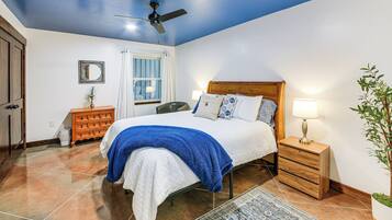 A bedroom with a bed, nightstand, dresser, and a ceiling fan.