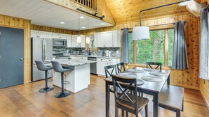 A modern kitchen with a central island, bar stools, and a dining table with chairs. - Serene Mountain Home: 11 Mi to Gettysburg (Fairfield)