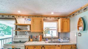 A kitchen with wooden cabinets, a stove, and a sink. - Woodsy 20-acre Retreat w/ Hot Tub in Mancelona (Mancelona)
