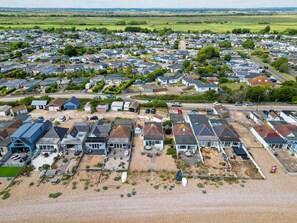 An aerial view of a residential area with houses, some with attached garages, and a few with visible driveways. - The Beach House in Pevensey Bay (Pevensey)