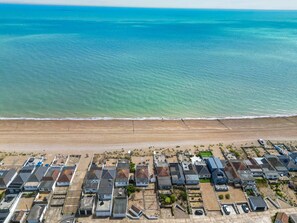 An aerial view of a coastal residential area with houses and a beach. - The Beach House in Pevensey Bay (Pevensey)