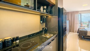 Een moderne keuken met een ingebouwde koffiezetapparaat, een spoelbak en een eethoek met een tafel en stoelen.