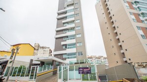 A multi-story building with a modern architectural design, featuring balconies, large windows, and a gated entrance. - Beautiful Apartment in Salvador Rmo0602 (Salvador)