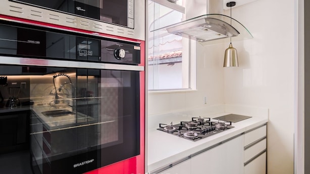 A modern kitchen with a built-in oven, a gas stove, and a glass-fronted microwave. - Modern Apartment 1km From Ondina Beach Slo0301 (Salvador)