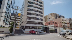 Un immeuble à plusieurs étages doté de balcons et d’une entrée sécurisée par un portail.