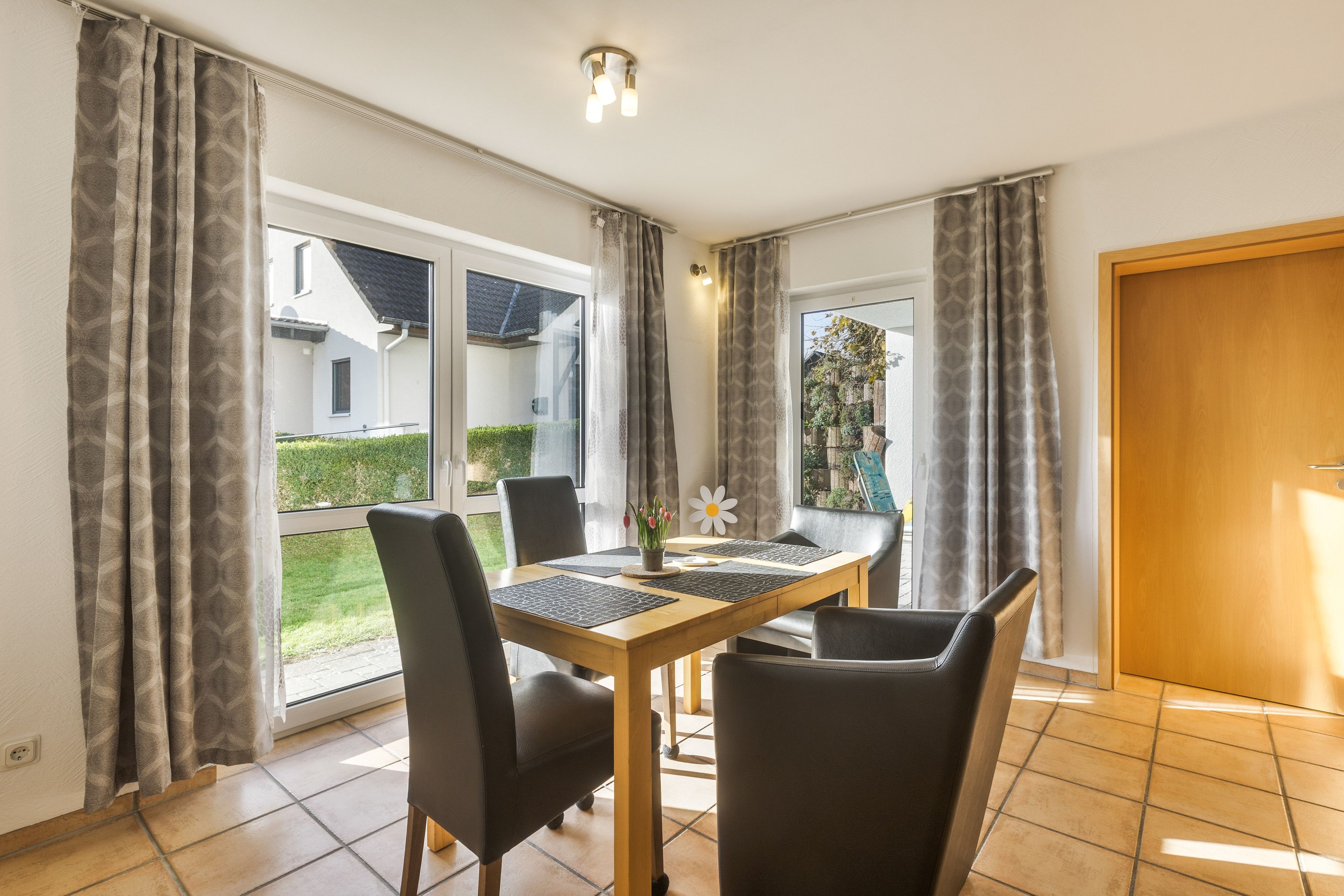 Un comedor con una mesa, sillas y vistas al exterior.