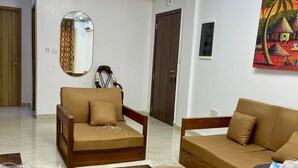 Uma sala de estar moderna com dois sofás, uma mesa de centro e um espelho.