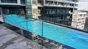 A rooftop swimming pool with a shallow area marked, surrounded by modern buildings. - Luxury 2 Bedrooms appartment near CN tour (Toronto)