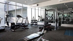 Un gimnasio moderno con cintas de correr, máquinas de pesas y pesas libres.