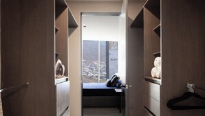 Un vestidor con cama y vistas a un pueblo a través de un amplio ventanal.