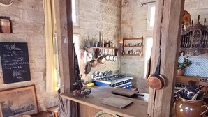 A rustic kitchen with wooden beams, a stone wall, and a chalkboard menu. - House, gîte, apartment, private mansion with character historic center Pézenas (Pézenas)