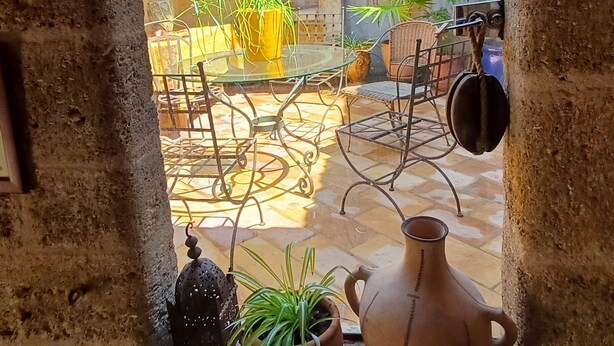 A rustic courtyard with a glass table, potted plants, and a clay pot. - House, gîte, apartment, private mansion with character historic center Pézenas (Pézenas)