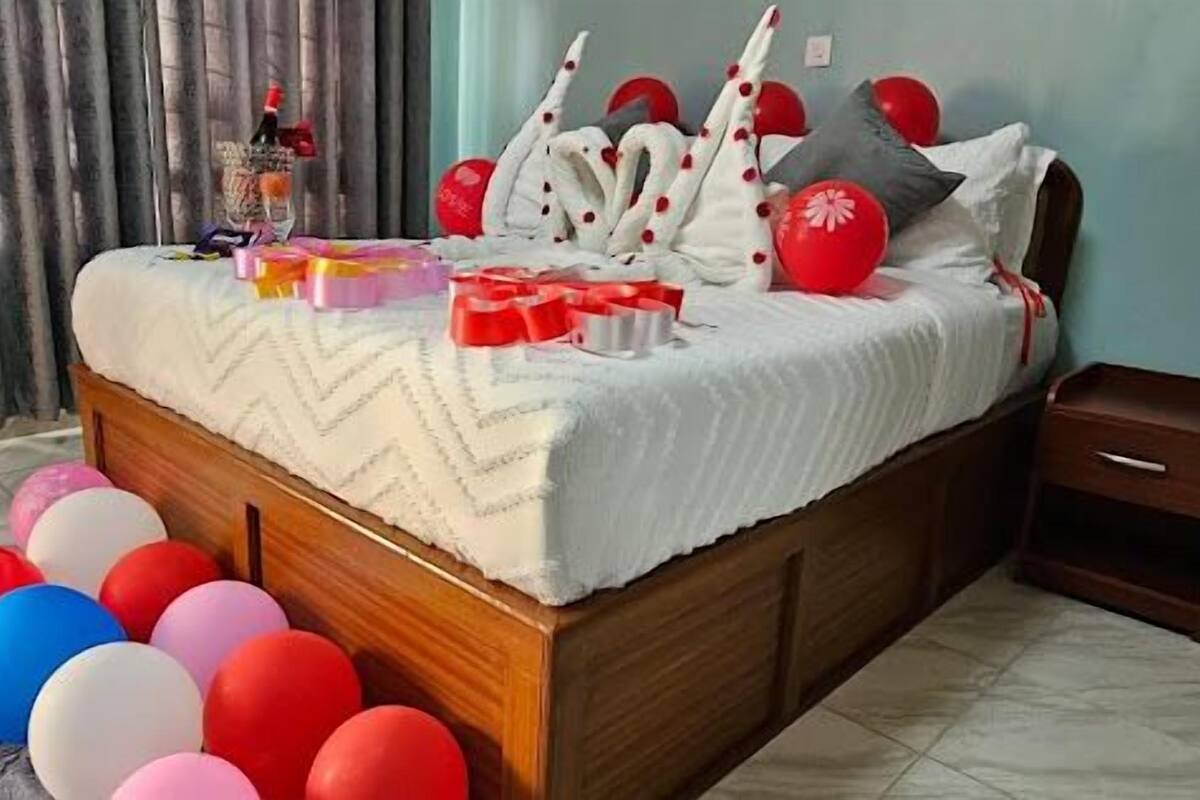 Une chambre à coucher avec un lit, une table de chevet et un rideau.