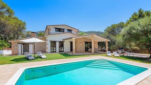 A modern house with a swimming pool, a covered patio, and a well-maintained lawn. - VILLA SON TONI (Crestatx)