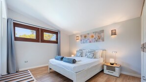 A bedroom with a bed, bedside tables, a nightstand, a window, and a painting on the wall. - VILLA SON TONI (Crestatx)