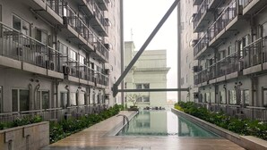 A modern building with a central pool, surrounded by balconies and greenery. - Green Residences Taft Ave. by darpm (Manila)
