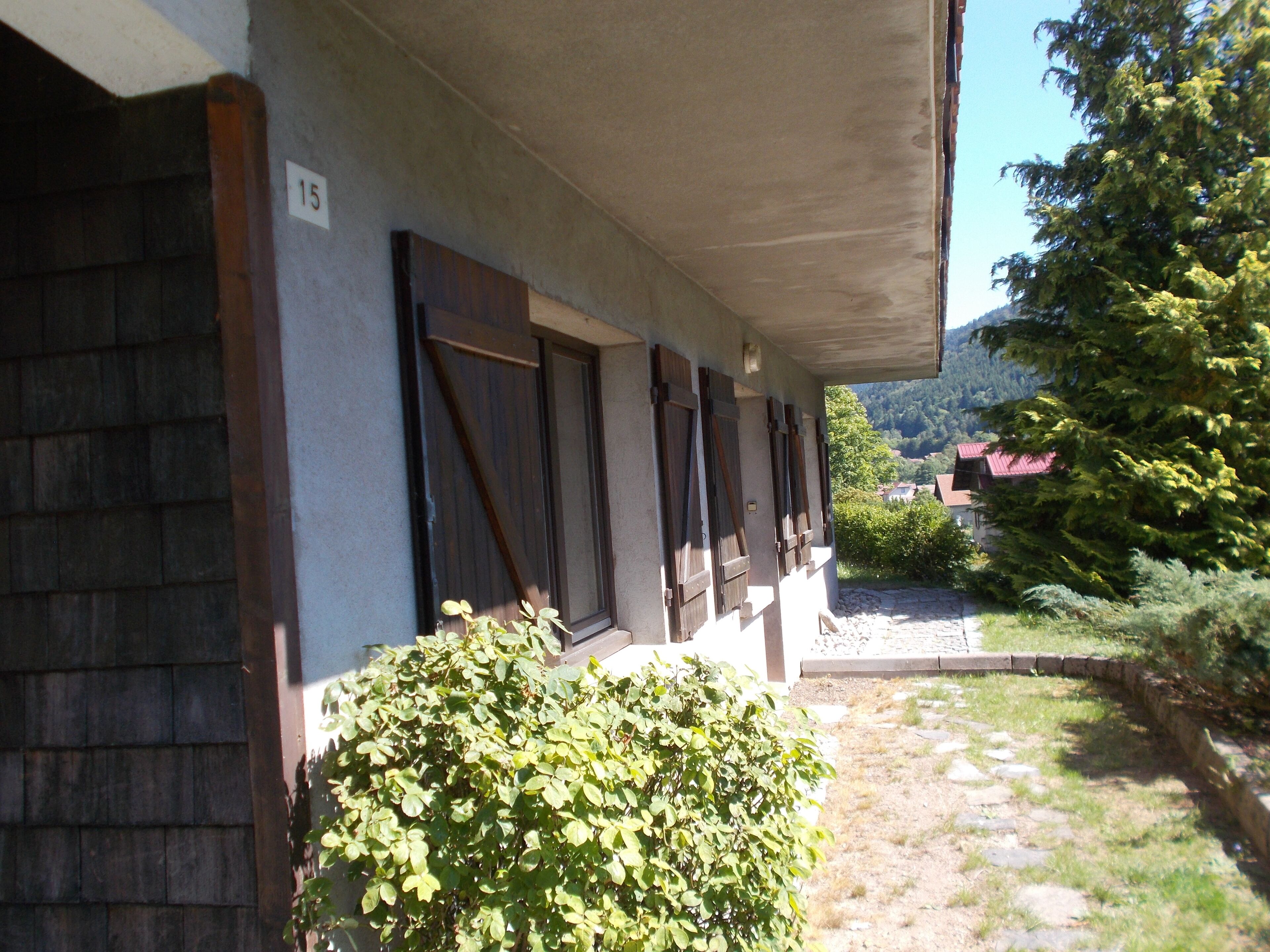Ein Gebäude mit einer Veranda, Holzläden und einem Schild mit der Nummer 15.