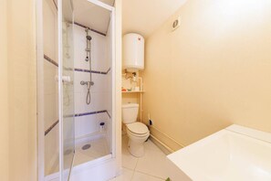 Ein Badezimmer mit Duschkabine, Toilette und Badewanne.