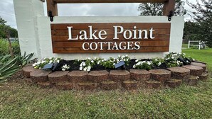 Une enseigne pour le complexe de chalets « Lake Point », avec un cadre en bois et des lettres blanches.
