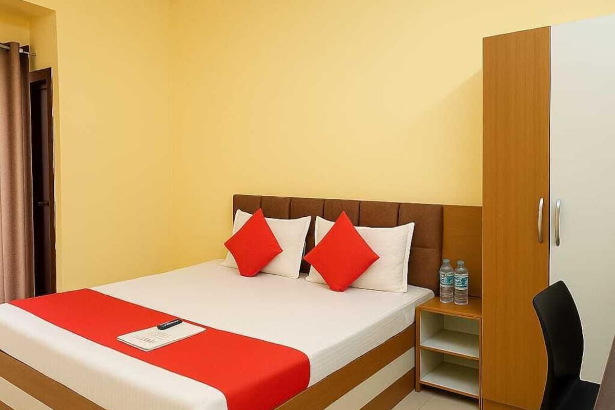 Una habitación de hotel con cama, escritorio y armario.