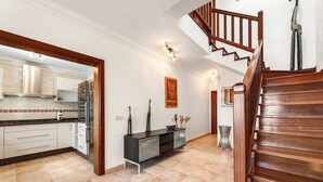 Una cocina amplia con electrodomésticos modernos, una escalera de madera y un adorno decorativo en la pared.