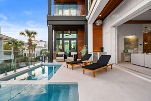 Un área de piscina moderna con sillones de descanso y vista despejada a la piscina.