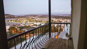 Ein Balkon mit Blick auf einen Stadtblick, einschließlich Gebäude und eines Gewässer.