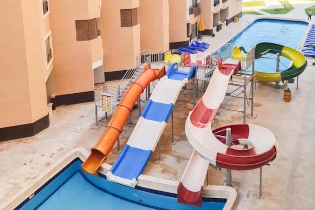 Et poolområde med flere vandrutsjebaner og en swimmingpool.