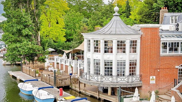 A riverside dock with boats, a gazebo, and a brick building with a sign. - Palace Gate, Hampton Court (East Molesey)