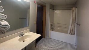 Une salle de bain avec un lavabo, un miroir et une douche.