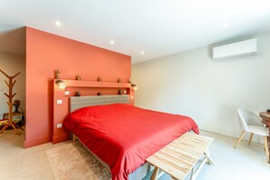 Un dormitorio moderno con cama, escritorio y silla.