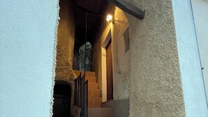A narrow stairway leading to a second-floor landing with a wooden handrail and a light fixture above. - Stay in the tranquility of Badolato's ancient, atmospheric streets (Badolato)