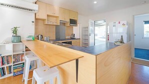 A modern kitchen with wooden cabinets, a central island, and a built-in oven.